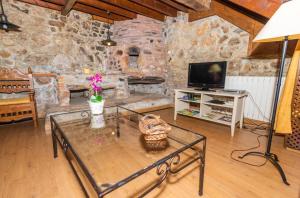 a living room with a glass table and a stone fireplace at Casa Horno in Robledo