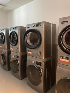 four washers and dryers are lined up in a room at Small cozy apartment, coffee and parking free in Trnávka