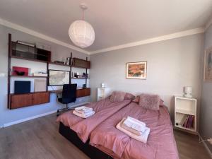 Homely flat with amazing views في ريكيافيك: غرفة نوم بسرير كبير مع بطانية وردية