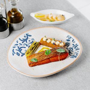 a plate of food with fish and pasta on a table at Qafqaz Tufandag Mountain Resort Hotel in Gabala