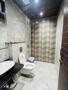 a bathroom with a toilet and a sink at Goel Villa and Hotel in Allāhābād Junction