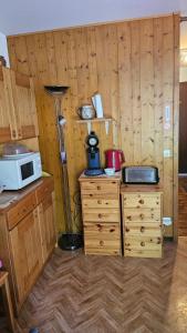 里雾诗Studio pieds des pistes les Houches Vallée de Chamonix的厨房设有木墙,柜台上配有微波炉 更多4张照片