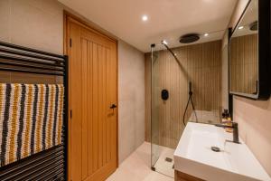 une salle de bain avec un lavabo blanc et une douche dans l'établissement Berristall Head Farm Cottage, à Purmerend 17 autres photos