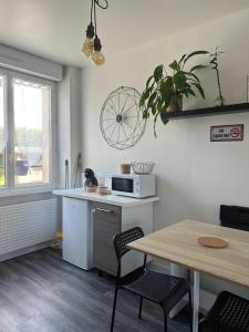 kuchnia ze stołem i kuchenką mikrofalową w obiekcie joli T1 avec parking gratuit w mieście Brest