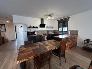 a kitchen and dining room with a wooden table at Paisible MAISON familiale - 4 Chambres - 2 SDB - terrasse et jardin - parking privé - Limoges in Limoges
