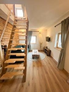 a room with a wooden staircase in a house at Künstlerstubn in Hartneidstein