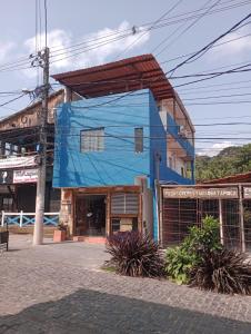 a blue building on the side of a street at Apartamento e suítes Itacaré in Itacaré