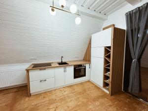a kitchen with white cabinets and a sink in a room at A Frame Girasole in Colibiţa