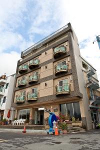 a building with a blue fire hydrant in front of it at Ibizakenting Hotel in Kenting