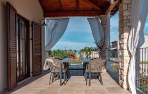 a patio with a table and chairs on a balcony at Beautiful Villa Lere with pool in Liznjan in Šišan