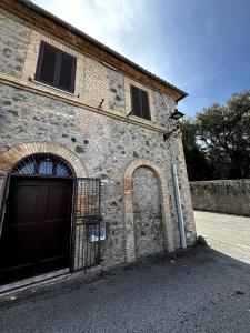 un edificio de ladrillo con puerta y puerta en Appartamento Aurelia, en Castel Viscardo