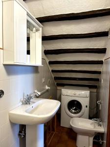 Un baño con lavabo y lavadora. en Appartamento Aurelia, en Castel Viscardo