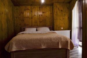 Un dormitorio con una cama en una pared de madera. en Hotel Nine 9, en Bakuriani