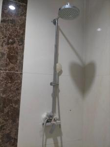a shower with a shower head in a bathroom at Kouzui Homestay in Surabaya +9 photos