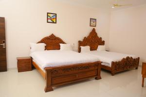 two beds in a room with white walls at Saba executive rooms and apartments in Hyderabad