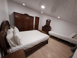 a bedroom with two beds and a dresser in it at Vivenda do Américo in Juncal