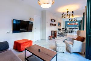 a living room with a couch and a tv at Holi-Rent Penthouse Peñuelas in Seville