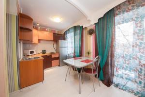 a kitchen with a table and chairs in a room at Kvartirov Apartment at K.Marksa in Krasnoyarsk