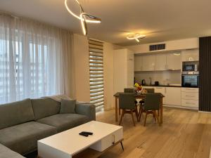 een woonkamer met een bank en een tafel bij Sarajevo Waves Aparthotel in Sarajevo