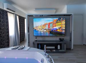 a bathroom with a tv and a bath tub in a room at Suite17 - Luxury GuestHouse in Giovinazzo