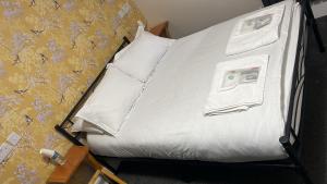 a bed with white sheets and pillows next to a wall at Woolaway in Taunton +4 photos