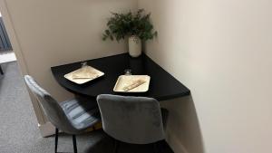 a black table with two chairs and a plant on it at Woolaway in Taunton
