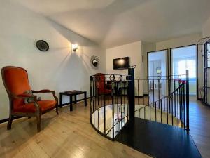 a living room with a chair and a table at Côté Cité appartements - Parking privé - 100m Cité médiévale in Carcassonne
