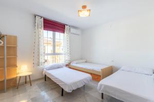 a room with two beds and a window at Chalet con piscina a 10 minutos de Granada in Ogíjares +26 photos