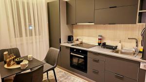 a kitchen with a sink and a table with chairs at Aparte - Standard in Pristina