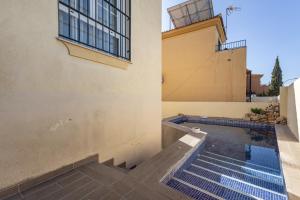 a swimming pool on the side of a building at Chalet con piscina a 10 minutos de Granada in Ogíjares