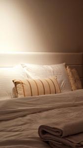 a bed with white sheets and pillows on it at Aparte - Standard in Pristina +10 photos
