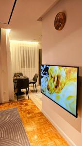 a living room with a flat screen tv on a wall at Aparte - Standard in Pristina