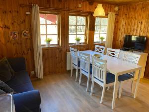 a dining room with a table and chairs at Kyrkekvarn Stugby in Sandhem