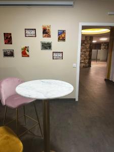 a white table and two pink chairs in a room at Apartamentos El Velero in Torremolinos