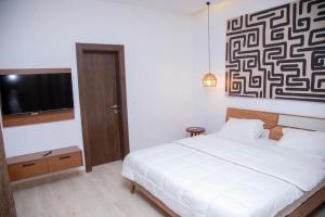 a bedroom with a bed and a flat screen tv at Villa paradisiaque à Assinie 10 personnes in Assinie +14 photos