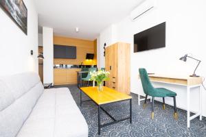 ein Wohnzimmer mit Sofa und Tisch in der Unterkunft Hotel ARDEN in Środa Śląska