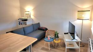 a living room with a blue couch and a table at Le Comptoir du Canal in Fleurey-sur-Ouche