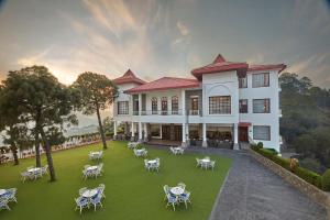卡绍利Fortune Select Forest Hill, Kasauli - Member ITC Hotels' Group的享有带桌椅的建筑的外部景色。