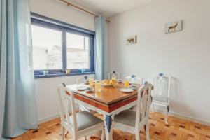 una sala da pranzo con tavolo, sedie e una finestra di Blue Villa by Hosty a Porto