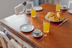 un tavolo con un piatto di pane e bicchieri di succo d'arancia di Blue Villa by Hosty a Porto Altre 70 foto