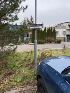 a street sign on a pole next to a car at Apartmán Dominanta in Liptovský Mikuláš