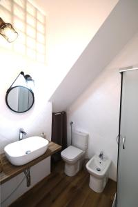 a bathroom with a sink toilet and a mirror at La casetta del cortile in Siracusa
