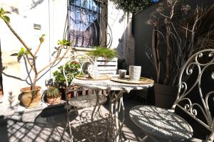 a table and chairs on a patio with plants at La casetta del cortile in Siracusa