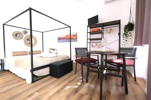 a bedroom with a bed and a table and a desk at La casetta del cortile in Siracusa