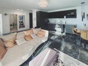 a living room with a white couch and a kitchen at Violet Superior in Nyíregyháza +47 photos