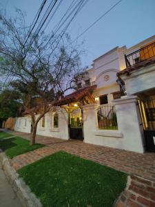 a large white house with a tree in the yard at La Posta Tigre in Tigre