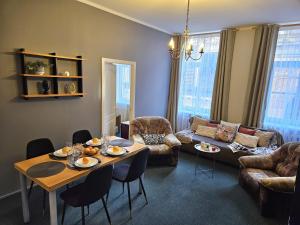 a living room with a table and a couch at Heart of Old Riga 3 Bedroom Apartment by Dome Square in Rīga