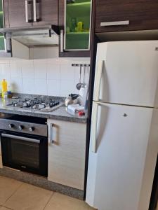 a kitchen with a white refrigerator and a stove at Casa olivos villa 100m de la plage in Al Hoceïma