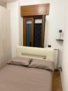 a bedroom with a white bed with a window at Little House in Fiumicino