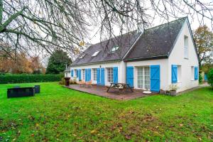 une maison blanche et bleue avec une table de pique-nique dans la cour dans l'établissement KER-MYR - Belle Maison de campagne familiale proche sentiers côtiers, à Baden